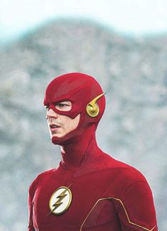 the flash standing in front of a mountain with his head turned to look like he is wearing