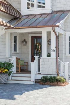 a white house with a metal roof and porch