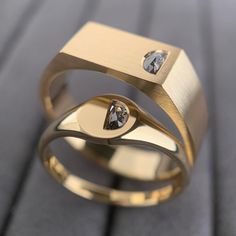 a gold ring with two diamonds on it