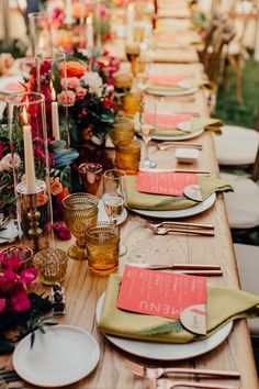 a long table set with place settings and candles