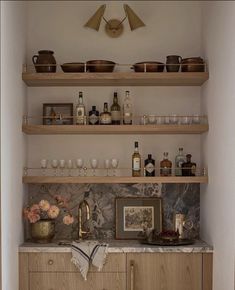 the shelves in this kitchen are filled with bottles and glasses