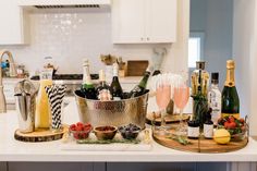 a kitchen counter topped with lots of bottles and glasses