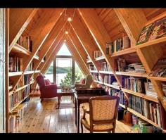 a room filled with lots of books and furniture next to a wooden wall covered in shelves