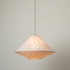 a light fixture hanging from a ceiling with a white wall in the background and a grey wall behind it