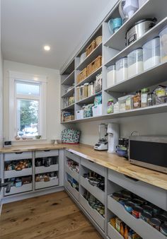 an organized kitchen with lots of shelves and bins