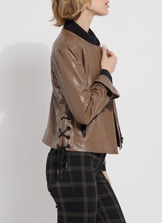 Made from 4-way stretch Textured Vegan Leather, the Kellie Bomber Moto Jacket features a cropped, slim fit, zip front, contrast-color ribbed jersey neck, back yoke, side pockets and gunmetal zip sleeves for easy cuffing. Combining bomber and moto jacket styling, the Kellie is an unlined jacket with a mesh yoke inside and a unique, side lace-up detail with metal eyelet and side ties. Layer the Kellie Bomber Moto over our Connie Slim Button Down and Patterned Baby Bootcut pants. Vegan Leather- 100 Fitted Cropped Jacket With Zipper For Fall, Versatile Fitted Brown Outerwear, Sleek Stretch Outerwear For Fall, Chic Brown Stretch Outerwear, Chic Stretch Brown Outerwear, Fitted Cropped Jacket With Zip Fly For Fall, Fitted Biker Jacket With Zip Cuffs For Spring, Brown Fitted Outerwear With Asymmetrical Zip, Fitted Brown Outerwear With Asymmetrical Zip