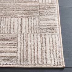 a close up of a rug on a wooden floor with dark wood floors in the background