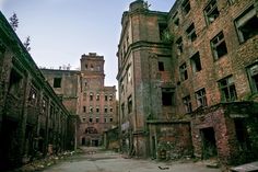 an old run down city street with lots of windows and brick buildings on both sides