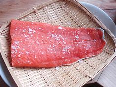 a piece of raw fish sitting on top of a basket