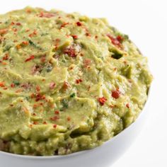 a white bowl filled with guacamole on top of a table