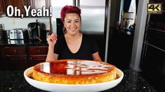 a woman sitting in front of a cake on top of a counter with the words oh yeah