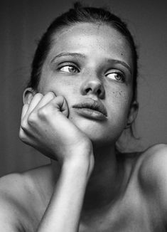 a black and white photo of a woman with freckles on her chest looking up at the camera