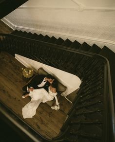 a bride and groom laying down on the stairs