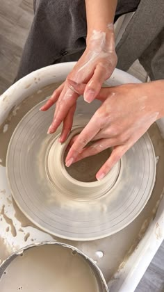 a person is making something out of clay on a potter's wheel with their hands