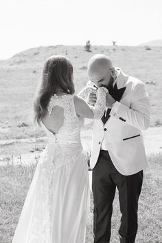 a man in a suit and tie standing next to a woman wearing a wedding dress