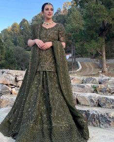 a woman in a green gown standing on some steps