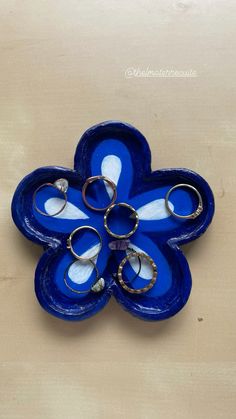 a blue flower shaped object sitting on top of a wooden table next to two pairs of scissors