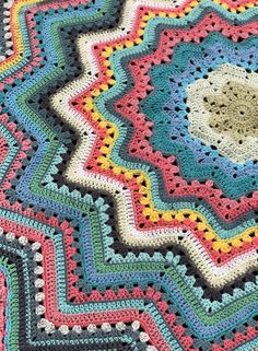 a crocheted blanket is shown on the floor with it's circular design