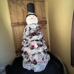 a snowman made out of burlocks and mesh sitting on top of a bed