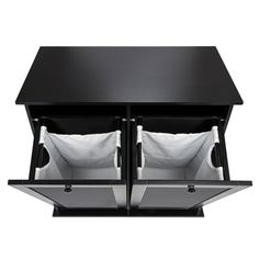 two black tables with white pillows on them and one is open to show the same item