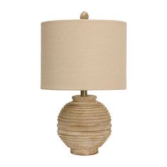 a table lamp with a beige shade on it and a white fabric lampshade