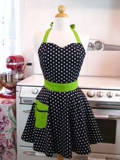 a black and white polka dot dress on a mannequin in front of an oven