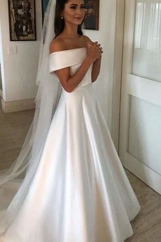 a woman in a white wedding dress is posing for the camera