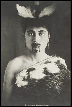 an old photo of a woman with feathers on her head and tongue sticking out to the side