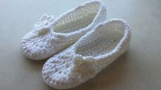 a pair of crocheted white slippers sitting on top of a countertop