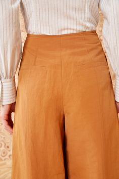 Our Polina Pant is a cropped, wide-leg beauty made from our signature suiting fabrication in a versatile tan hue. Exclusive to our boutiques and webshop, these high-rise pants are adorned with double-breasted buttons and are designed without a waistband for a sleek finish. Composition: 53% Cotton, 45% Linen, 2% Silk Style with our Arden Blouse and Mini Flower Stud Earring to complete the look. Beige Wide Leg Culottes For Workwear, Brown Wide Leg Pants With Welt Pockets, Cotton Straight Leg Culottes For Work, Elegant Cotton Culottes, Elegant High-waisted Cotton Culottes, Chic Brown Cotton Wide Leg Pants, Chic Cotton Culottes For Work, Chic Cotton Straight Culottes, Cotton Culottes For Workwear