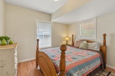 a bed room with a neatly made bed and wooden floors