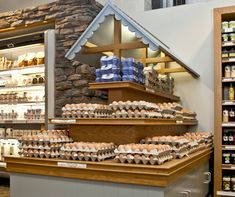 there are many eggs on the counter in this store, including one with a house shaped roof