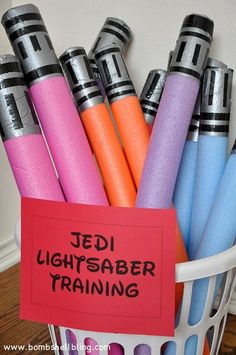 a basket filled with different colored pens next to a red sign that says ted light saber training