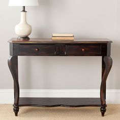 a wooden table with two drawers and a white vase on it's end stand