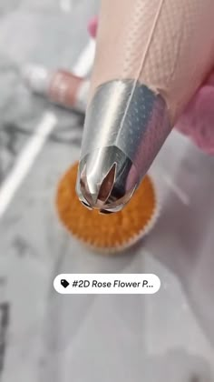 a person is using a brush to polish their nails on top of an orange object