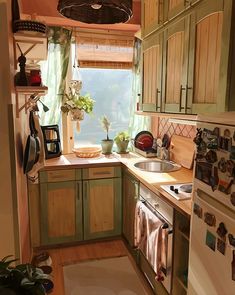 a small kitchen with green cabinets and wood flooring is pictured in this image from the doorway