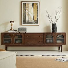 a living room scene with focus on the sideboard and vases in the center