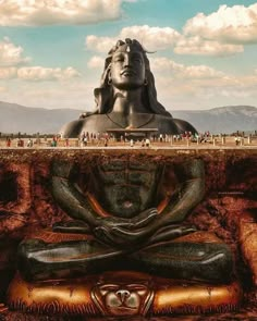 a large buddha statue sitting in the middle of a field