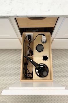 an overhead view of a kitchen drawer with hair dryers and other items in it