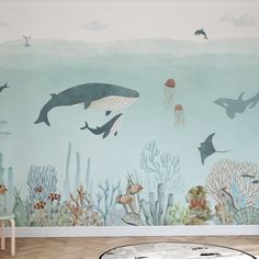 an ocean scene with dolphins, jellyfish and other marine creatures painted on the wall