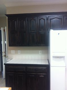 a white refrigerator freezer sitting inside of a kitchen next to wooden cupboards and cabinets