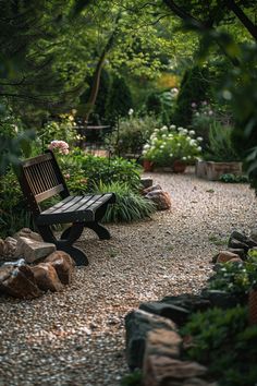 a wooden bench sitting in the middle of a gravel path surrounded by trees and bushes