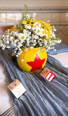 a vase filled with flowers on top of a table next to a name tag and tags