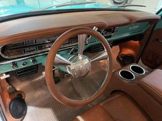 the interior of an old car with brown leather seats and steering wheel, including center console