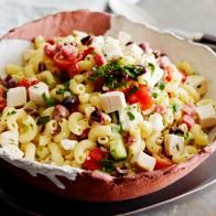 a bowl filled with pasta salad on top of a table