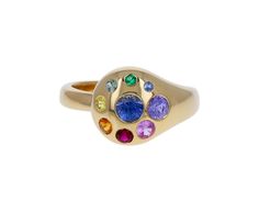 Wear this colorful Brent Neale ring as a stylish, modern alternative to the traditional cocktail ring. The polished 18K yellow gold circular ring face is set with a round pale blue sapphire at the center surrounded by a halo of smaller rainbow sapphires varying slightly in size. Whether worn on your ring finger or as a cocktail ring, this sparkler begs for a closer look.ring face : just under 1/2" diameterrainbow sapphires : vary : 1.5mm diameter to 4.5mm diameter each18K yellow gold band width Multicolor Sapphire Ring, Multicolor Round Sapphire Ring Fine Jewelry, Multicolor Sapphire Ring Fine Jewelry, Yellow Gold Multi-stone Dome Ring, Yellow Gold Multi-stone Sapphire Ring, Rainbow Multi-stone Round Sapphire Ring, Rainbow Multi-stone Round Rings, Brent Neale, Petal Ring