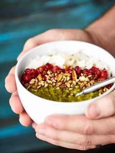 two hands holding a white bowl filled with food