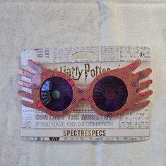 a pair of pink and purple sunglasses on top of a piece of paper with harry potter written on it