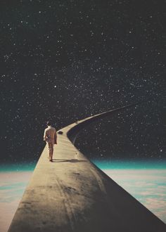 a man standing on top of a long piece of concrete with stars in the sky