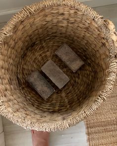 a person standing next to a wicker basket on the floor with blocks in it